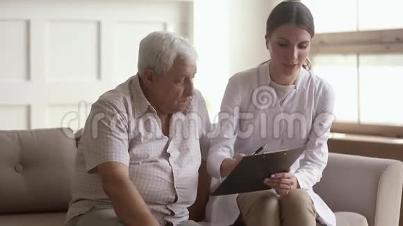 年轻女性护士照顾者拿着剪贴板咨询老人视频的预览图