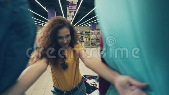 快乐的女士把衣服放进商店的手提箱里视频的预览图