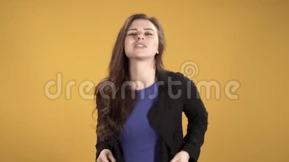 快乐的年轻女子在黄色的背景下拍打手指节奏和舞蹈视频的预览图