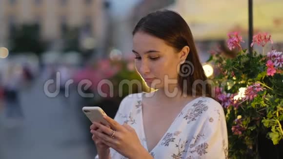 女人正在打电话站在城市大街上视频的预览图