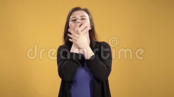 愤怒的年轻女子用双手遮住她的脸用黄色的背景视频的预览图