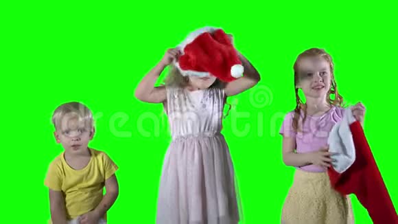 淘气的孩子头上戴着圣诞帽绿色屏幕背景视频的预览图