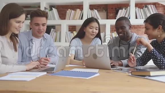 快乐的焦点多样化的学生在电脑上成群结队地工作视频的预览图