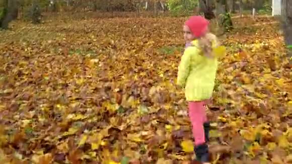 镜头跟随小女孩跑过秋天多姿的公园万向节视频的预览图