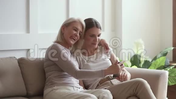 积极的成熟母亲和成年女儿在电话里自拍视频的预览图