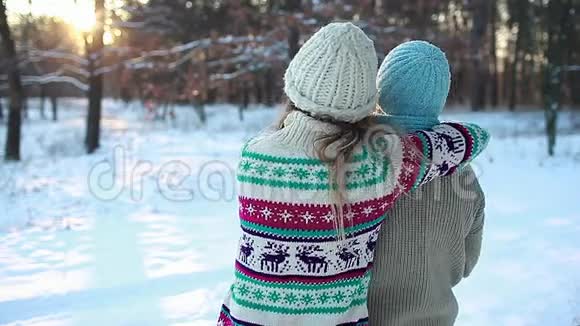 家人拥抱在冬天的森林里穿着温暖的毛衣欣赏风景母亲和女儿在户外玩得很开心视频的预览图