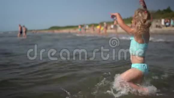 活跃贪玩的小女孩在海水中涉水跳舞有趣的孩子视频的预览图