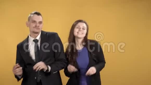 快乐的年轻人在黄色的背景下拍着手指的节奏跳舞视频的预览图