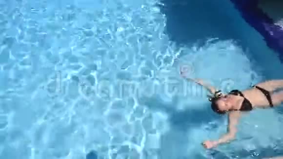 一个穿着黑色泳衣的漂亮女孩正在水里游泳视频的预览图