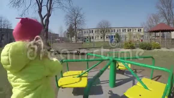 城市公园操场上五颜六色的秋千上的小女孩快乐活泼的孩子视频的预览图