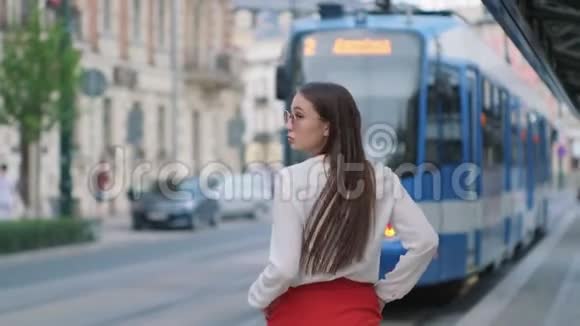 女性城市居民在城市的电车站上行走视频的预览图