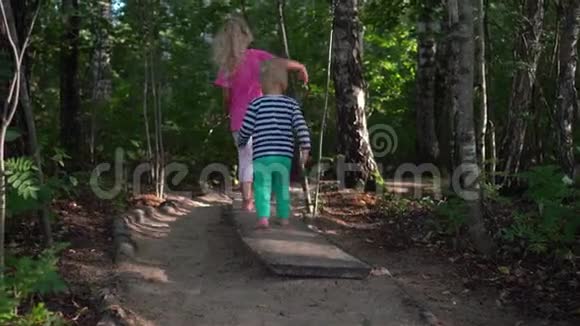 姐弟赤脚走过小路活动儿童步行板视频的预览图
