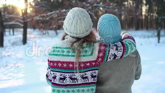 家人拥抱在冬天的森林里扔雪享受风景妈妈和女儿散步很开心视频的预览图