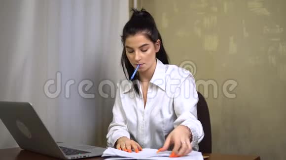 专注的年轻上班族秘书看着笔记本电脑做笔记视频的预览图