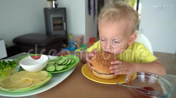 欧洲白人孩子吃美味的大汉堡胃口很好万向节运动视频的预览图