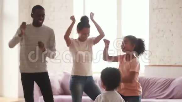 快乐的非洲父母和可爱有趣的孩子在家跳舞视频的预览图