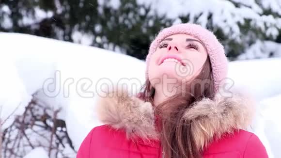 开朗的年轻女子正在喝外卖咖啡而在冬天散步下雪视频的预览图