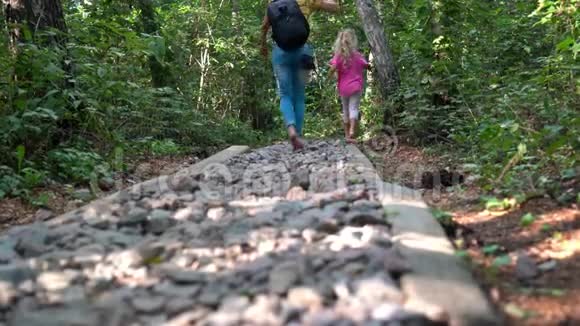 带着小女孩的女人带着小石头走过崎岖的小径足部按摩视频的预览图