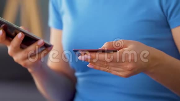 女人坐在沙发上把信用卡号码输入智能手机在线支付网上购物生活方式视频的预览图