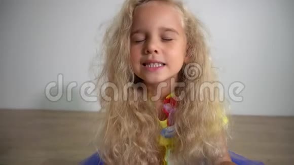 四岁的女孩在房间的地板上放松冥想金发卷发孩子视频的预览图
