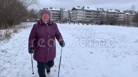 戴眼镜的漂亮老年妇女从事北欧步行活动视频的预览图