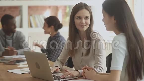 可爱的白种人女孩和越南朋友在电脑上工作视频的预览图