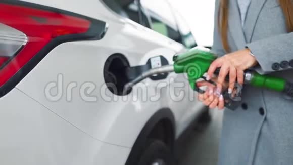 在加油站的一个特写镜头里女人往她的车里灌汽油慢动作视频的预览图