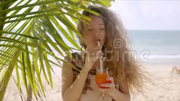 棕榈树旁迷人的女性饮料视频的预览图