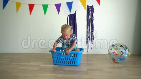幼儿小男孩从洗衣盒上摔下来玩球万向节运动视频的预览图