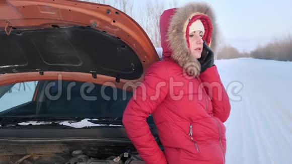 一个穿着红色冬装的女孩站在一辆破车旁边哭着视频的预览图