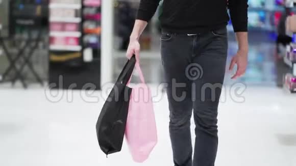 近距离人们的双腿在购物中心散步手里拿着购物袋视频的预览图