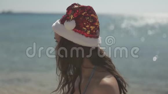 戴红帽子的圣诞假期女孩红海滩视频的预览图