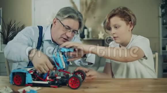 老人和他的孙子正在组装一辆玩具车视频的预览图