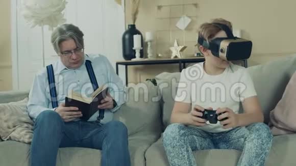一个男孩正在玩虚拟现实眼镜而他的爷爷在看他视频的预览图