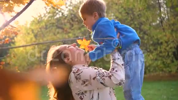 一个妈妈和一个孩子玩把他抱在怀里吐了出来太阳阳光透过孩子他的笑声和欢乐视频的预览图
