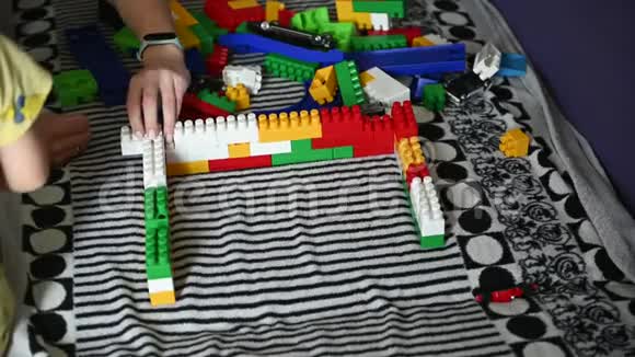 快乐的孩子在条纹沙发上的彩色积木里玩耍视频的预览图