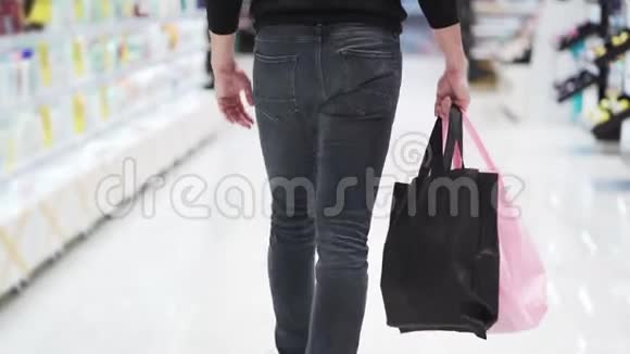 关门男人走进购物中心手里拿着彩色购物袋视频的预览图