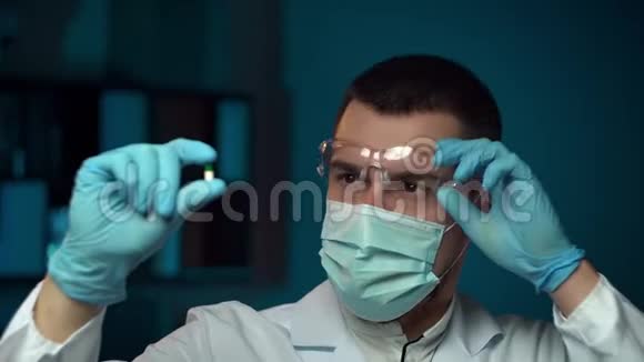 一位在实验室里分析药丸的男性科学家的特写视频的预览图