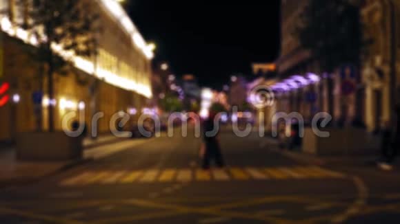 对夜城街道的分散视野汽车沿着这条路行驶人们走路视频的预览图
