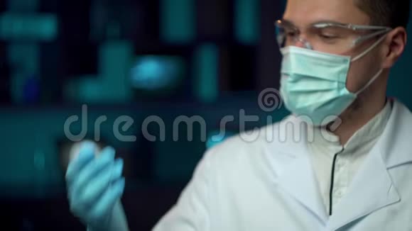 一名戴口罩的实验室工作人员戴上防护眼镜以便在实验室工作视频的预览图