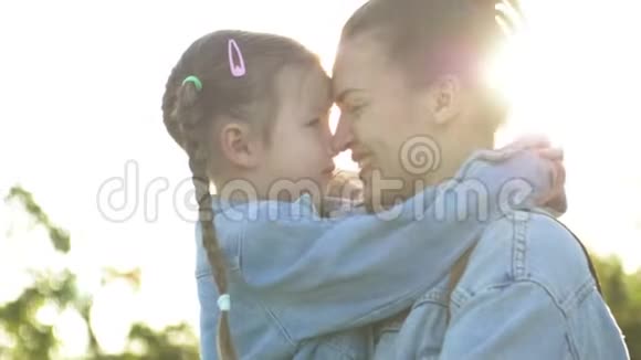 幸福的家庭母亲和孩子在公园的户外玩得开心可爱的女孩在玩拥抱和亲吻她的母亲视频的预览图