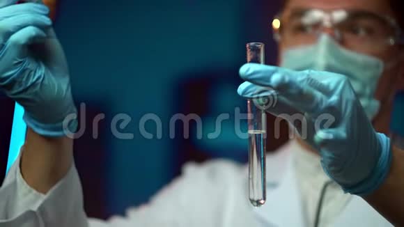 在一个未来的实验室里一位拿着吸管的科学家分析了一种有色液体来提取DNA和分子视频的预览图