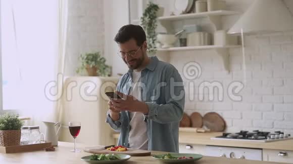 快乐的年轻人用智能手机应用程序准备浪漫晚餐视频的预览图