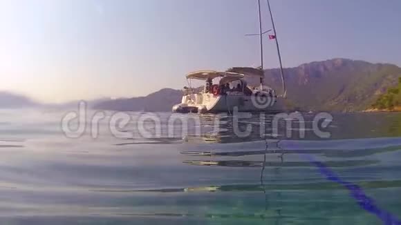 在美丽的海湾航行游艇从水中拍摄海浪视频的预览图