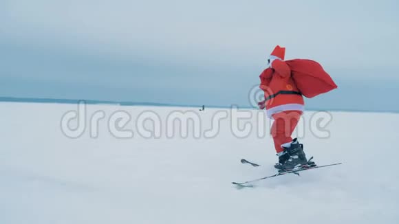 一个圣诞老人在滑雪时拿着一个带礼物的袋子侧视视频的预览图