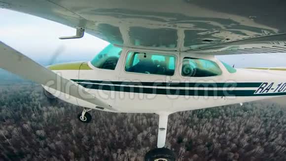 一架小型飞机正从森林的侧面飞过视频的预览图