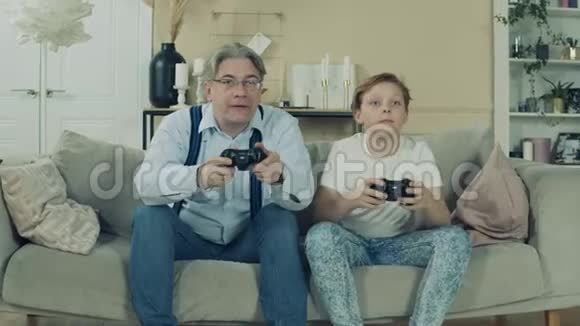 一个男孩和他的祖父玩电子游戏视频的预览图