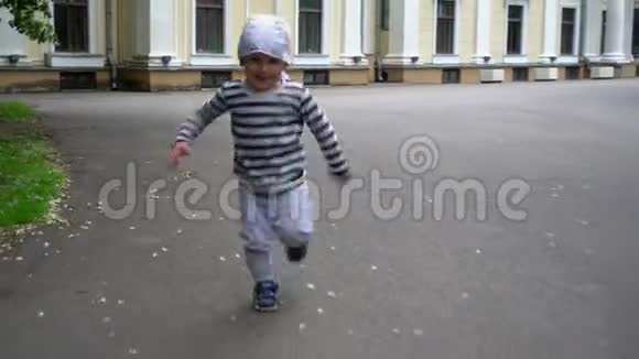 活跃的幼儿男孩在公园的沥青路上跑步关节活动度射击视频的预览图