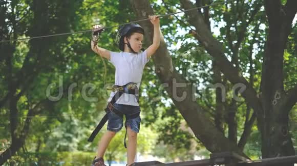 一个小男孩在一个绳索公园里经过一个景点视频的预览图