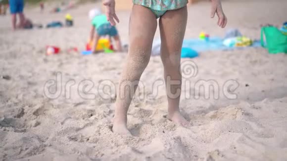 兴奋的金发女孩浑身是沙滩沙挥舞着双手看着镜头视频的预览图